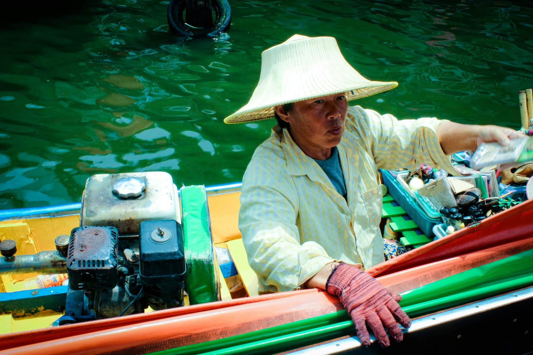 Vendor in a colourful boat on a Southeast Asian waterway